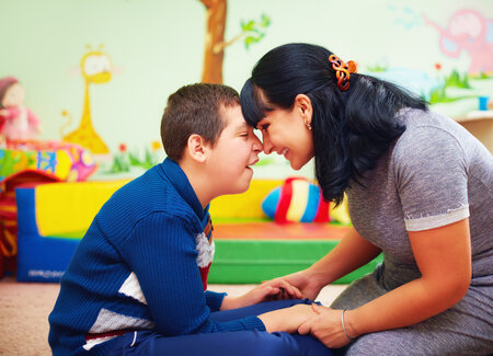 child and female therapist holding hands